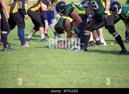 American football giocatori sulla linea di scrimmage pronto per entrare in azione Foto Stock