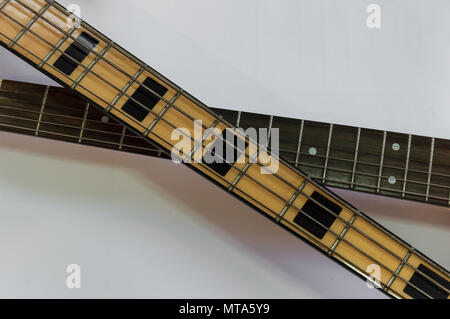Fretboard o collo di due strumenti musicali, una chitarra elettrica e un bass isolato su sfondo bianco con copia spazio. Foto Stock
