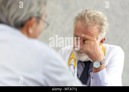 Senior di medico o di medico capo dando una consultazione per il suo paziente di sesso maschile e spiegando le informazioni mediche e diagnosi presso la clinica o hos Foto Stock