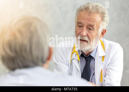 Senior di medico o di medico capo dando una consultazione per il suo paziente di sesso maschile e spiegando le informazioni mediche e diagnosi presso la clinica o hos Foto Stock