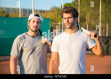 Due tennisti professionisti con hard-di fronte ragazzi su un campo da tennis. Foto Stock