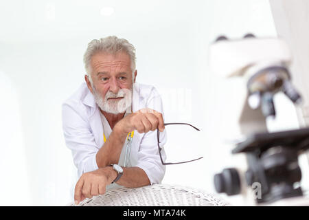 Medico i vecchi o gravemente scienziato che lavora con un microscopio in laboratorio. Foto Stock