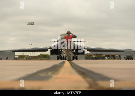 Stati Uniti Air Force Airman 1. Classe possibilità Barfield, 7 Manutenzione aeromobili squadrone capo equipaggio, marescialli Il Mag. Gen. Thomas Bussiere, 8 Air Force commander, verso la pista per un B-1B Lancer familiarizzazione volo a Dyess Air Force Base in Texas, 19 aprile 2017. Durante la sua visita, Bussiere è stata data la possibilità di volare in B-1 per capire il bombardiere il ruolo critico per la sicurezza e la dissuasione mentre a casa e all'estero. Foto Stock