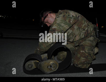 Airman Anson Stuart, 455th Expeditionary ingegnere civile Squadron, Reeves il nastro in un connettore a nastro 20 aprile 2017, a Bagram Airfield, Afghanistan. Il connettore a nastro è fissato al gancio cavo, che è la parte del velivolo Mobile sistema di arresto che cattura un atterraggio aerei. Foto Stock