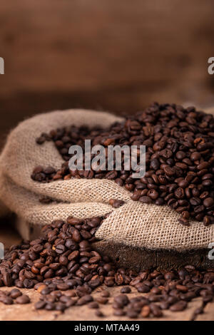 Sacco di schizzi di caffè fresco fagiolini sullo sfondo marrone Foto Stock