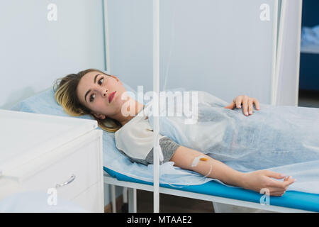 Malinconici donna trasfusa giacente in ospedale Foto Stock