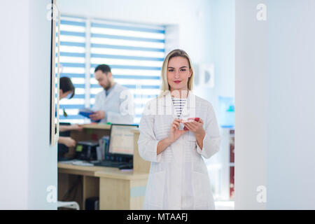 Ritratto di felice chirurgo femmina messaggio di lettura al telefono cellulare Foto Stock