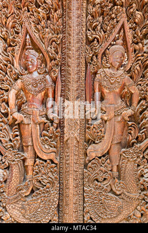 Figure scolpite in porta a Wat Luang Pakse, tempio di Pakse, Laos Foto Stock