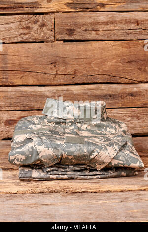 Ripiegate i vestiti militari. Il camuffamento soldato uniforme su legno. Foto Stock