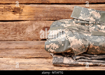 Close up piegati cilothes militare. Scrivania in legno sfondo di superficie. Foto Stock
