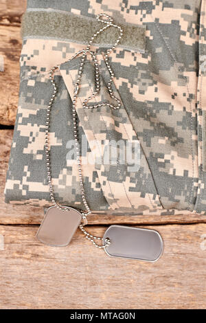 Soldato Abbigliamento camouflage e dog tag. Scrivania in legno sfondo di superficie. Foto Stock