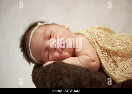 Neonato tenendo nap vicino la vista su sfondo lucido Foto Stock