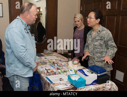 Il Mag. Marilyn Lai, 66Medical Squadron all'ottico optometrista, colloqui con Douglas Miller durante il pensionato militare apprezzamento giorno al Minuteman Commons Aprile 21, mentre Abigail Tarbox, 66 MDS optometria tecnico, ascolta. La manifestazione di quest'anno è iniziato con un Information Services sessione seguita da una presentazione dalla frode guardare la rete. Foto Stock