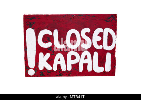 Chiuso segno kapalı scritto a mano sia in turco ed inglese su un rosso tagliere in legno con vernice bianca. Isolato su sfondo bianco. Foto Stock