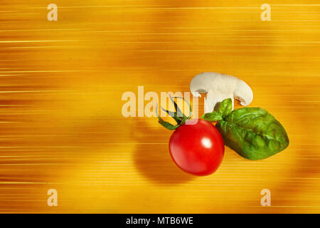 Vista superiore del pomodoro ciliegino, funghi e basilico su materie spaghetti sfondo. Concetto di spaghetti al sugo di preparazione. Foto Stock