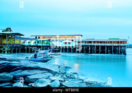 La spiaggia di sabbia e mare con barca da pesca che parcheggiato sul fronte spiaggia con rock e reef in mattinata con sunrise, bellissimo cielo con il mare e la pesca Foto Stock