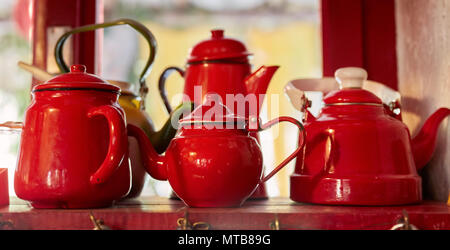 Vintage red teiere sul ripiano in legno di un antico paese di cucina domestica Foto Stock