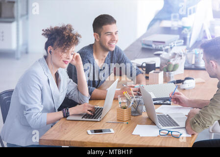 I colleghi aventi un gioioso di discussione nel loro ufficio durante una pausa Foto Stock