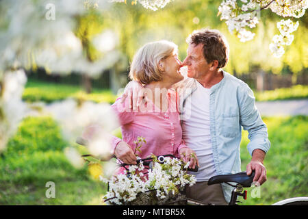 Bella coppia senior con le biciclette al di fuori in primavera la natura. Foto Stock