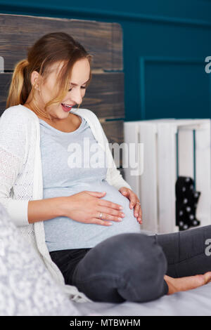 Sorpreso donna incinta toccando il suo ventre Foto Stock