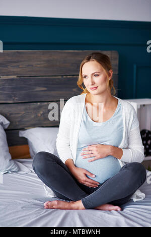 Ritratto di donna incinta in camera da letto Foto Stock