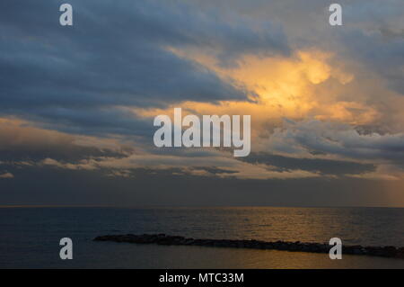 Tramonto sul mare Mediterraneo dal punto di vista dell'Italia, con cielo molto nuvoloso Foto Stock