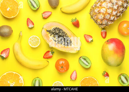 Organico mature tagliate a metà le fragole Kiwi Ananas Papaia Mango Agrumi banane Pattern su sfondo giallo. Luminoso di colori. Piatto Ar laici Foto Stock