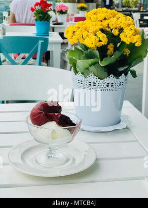 Organici di Berry sorbetto gelato sfere nella coppa di vetro con fiore dello sfondo. Tradizionale cibo d'estate. Foto Stock