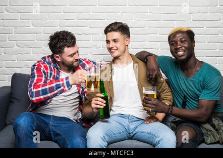 Happy amici maschi con vuvuzela guardare eventi sportivi in TV Foto Stock