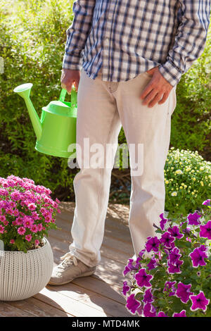 L'uomo giardiniere holding annaffiatoio in giardino Foto Stock