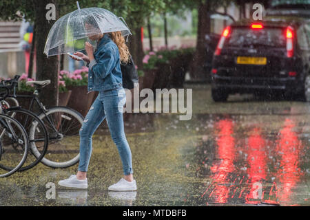 Southbank, Londra. 29 Maggio, 2018. Regno Unito Meteo: la gente lotta con ombrelloni come provano a camminare intorno al Southbank nel vento e pioggia. Credito: Guy Bell/Alamy Live News Foto Stock