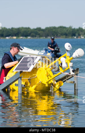 29 maggio 2018, Germania, Magdeburg: Burkhard Kuehn (L), ingegnere della Helmholtz-Zentrum für Umweltforschung (lit. Helmholtz-Center per la Ricerca Ambientale), si abbassa di una boa measrung nell'acqua della Barleber vedere (Lago Barleben). La boa è stato installato presso il lago per misurare la qualità dell'acqua. La qualità dell'acqua del Barleber vedere è stato problematico poiché 2016 e portato a restrizioni all'uso. Foto: Klaus-Dietmar Gabbert/dpa-Zentralbild/ZB Foto Stock