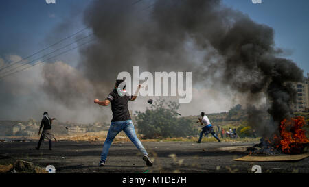 Ramallah, West Bank. 15 Maggio, 2018. I palestinesi si scontrano con le truppe israeliane in occasione del settantesimo anniversario della la Nakba. in Cisgiordania città di Ramallah. Il 1948 Exodus palestinese, noto anche come la Nakba, si è verificato quando più di 700.000 arabi palestinesi sono fuggiti o sono stati espulsi dalle loro case durante il 1948 palestina guerra, causando una crisi di rifugiati che deve ancora essere risolto. Credito: Eyad Jadallah/IMAGESLIVE/ZUMA filo/Alamy Live News Foto Stock