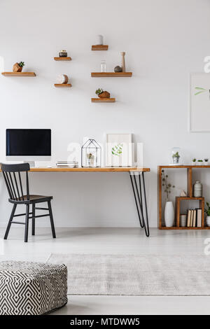 Pouf modellato in minima parte interna dello spazio di lavoro con sedia nero a tavola con il monitor di un computer. Foto reale Foto Stock