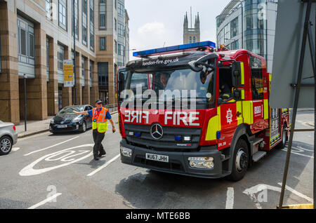 Un motore fire appartenenti al London Vigili del Fuoco la guida attraverso Hammersmith con luci blu e sirena rimbombava. Foto Stock