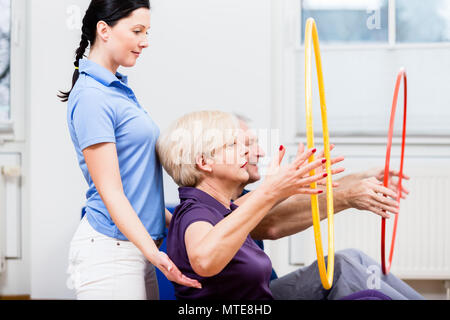 Coppia senior in fisioterapia fare esercizio con hula hoop Foto Stock