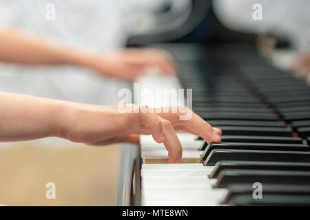 I bambini hanno le mani a suonare il pianoforte. Bambino la mano sui tasti di pianoforte Foto Stock