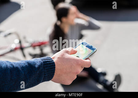 La mano di un uomo di chiamare il numero di emergenza per una donna malata Foto Stock