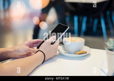 Ragazza giovane azienda telefono cellulare e lo sbloccaggio Foto Stock