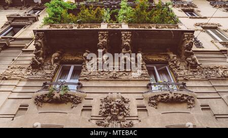 Facciata di edificio in Porta Venezia quartiere. Umanista ornamentali statue appeso alla parete. Architettura è presto 1900s natura ispirazione liberty, art-noveau style Foto Stock