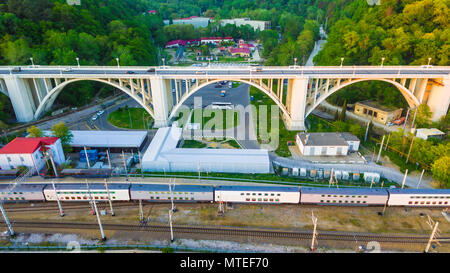 Drone Vista del viadotto Matsesta e ferrovia con treno sullo sfondo della fitta foresta nel giorno di estate, Sochi, Russia Foto Stock