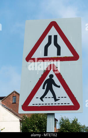 Inglese il traffico stradale triangolare di cartelli di avviso per la strada si restringe e le strisce pedonali, Regno Unito Foto Stock