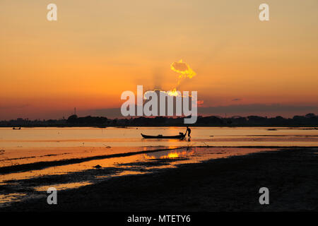 Barca tradizionale silhouette durante il tramonto su Taung Tha uomo Lago, Amarapura, Mandalay Myanmar Foto Stock