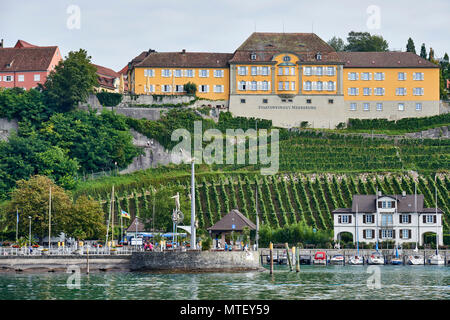 Staatsweingut Meersburg (cantina azienda vinicola) in cima al colle alle spalle del porto; vigne sulle colline fino al porto con statue uniche sui frangiflutti in f Foto Stock