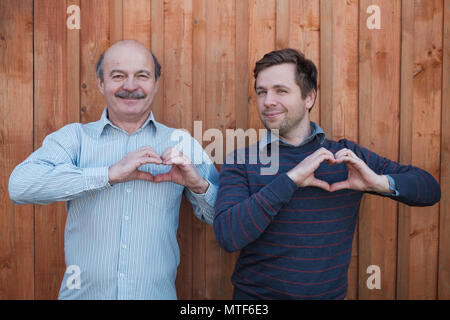 Due uomini caucaisan facendo un lato telaio del cuore. Foto Stock