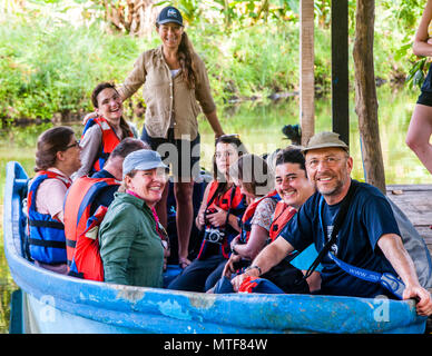 Team di Biosphere progetto di scienza dei cittadini per la protezione delle tartarughe marine in Costa Rica. Membri della spedizione al molo della stazione di ricerca. In piedi in barca: Leader spedizione Ida Vincent Foto Stock