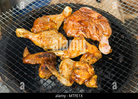 Barbeque le cosce di pollo arrostito sulla calda Flaming Brace, vista da vicino Foto Stock