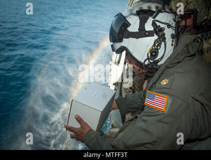 Lt. La Cmdr. Juan Cometa, un cappellano della marina militare assegnato al comandante, elicottero mare ala di combattimento del Pacifico, conduce una sepoltura in mare da un HH-60H Seahawk elicottero elicottero da combattimento del mare Squadron (HSC) 85 vicino a San Diego, California, 22 aprile 2017. HSC-85 fornisce dedicato ala rotante di supporto a U.S. Il Comando Operazioni Speciali in tutto il mondo. Foto Stock