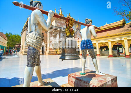 BAGAN, MYANMAR - Febbraio 24, 2018: una splendida scultura di un uomo che porta grande campana situato nel cortile del tempio Manuha, il 24 febbraio di Bagan Foto Stock