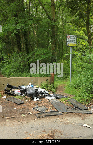 Rifiuti oggetto di dumping sotto una no fly segno di ribaltamento in campagna, UK. Foto Stock
